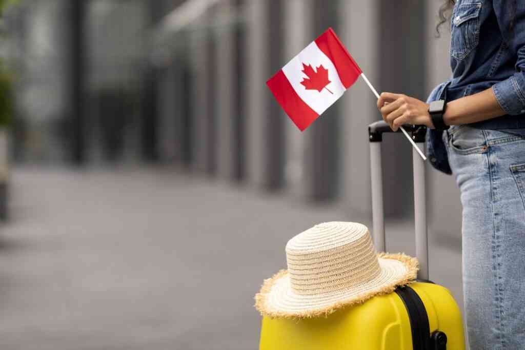 woman traveller holding flag of Canada, going abroad