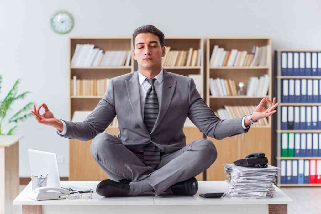 Handsome meditating on the office desk